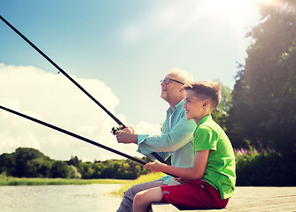 Image showing grandfather and grandson fishing on river berth