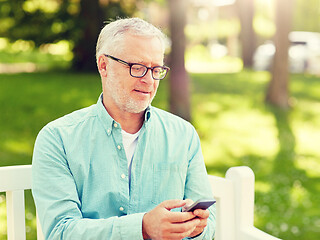 Image showing happy senior man texting on smartphone at summer