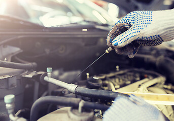 Image showing mechanic with dipstick checking motor oil level