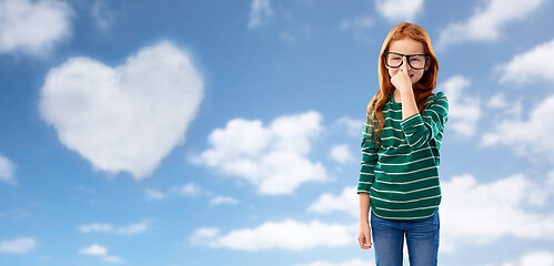 Image showing cute red haired student girl in glasses over sky