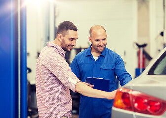 Image showing auto mechanic with clipboard and man at car shop