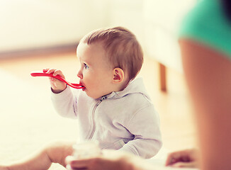 Image showing mother and baby with spoon eating at home