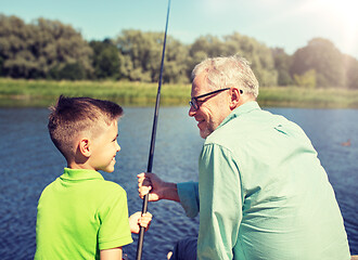 Image showing grandfather and grandson fishing on river berth