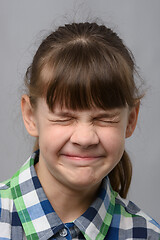 Image showing Portrait of a ten-year-old girl squinting her eyes, European appearance, close-up