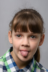 Image showing Portrait of a ten-year-old girl showing tongue, European appearance, close-up