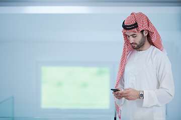 Image showing young arabian businessman using smartphone at home