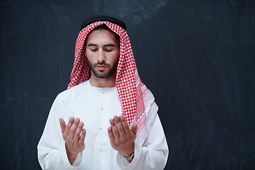 Image showing arabian man making traditional prayer to God, keeps hands in pra