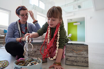 Image showing Mother and little girl daughter playing with jewelry  at home