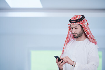 Image showing young arabian businessman using smartphone at home