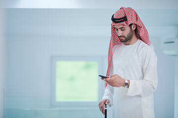 Image showing young arabian businessman using smartphone at home