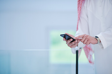 Image showing young arabian businessman using smartphone at home