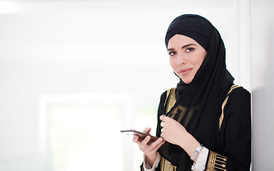 Image showing young modern muslim business woman using smartphone at home