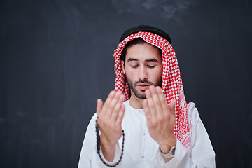 Image showing arabian man making traditional prayer to God, keeps hands in pra