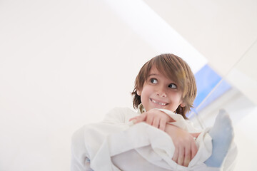 Image showing portrait of little arabian boy sitting on the glass floor