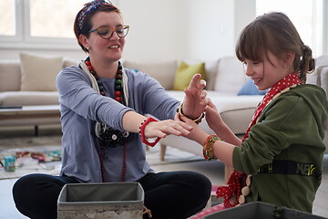 Image showing Mother and little girl daughter playing with jewelry  at home