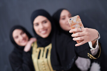 Image showing muslim women taking selfie picture in front of black chalkboard