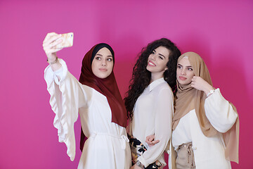 Image showing muslim women taking selfie picture isolated on pink