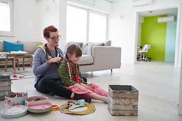 Image showing Mother and little girl daughter playing with jewelry  at home