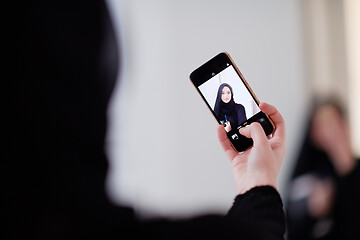 Image showing muslim woman taking selfie picture at home