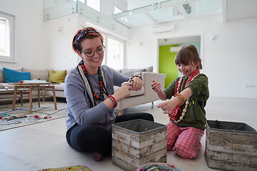 Image showing Mother and little girl daughter playing with jewelry  at home