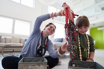 Image showing Mother and little girl daughter playing with jewelry  at home