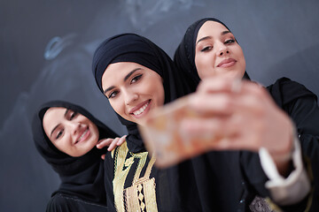 Image showing muslim women taking selfie picture in front of black chalkboard