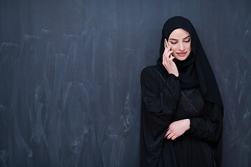 Image showing young modern muslim business woman using smartphone