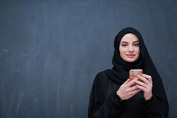 Image showing young modern muslim business woman using smartphone