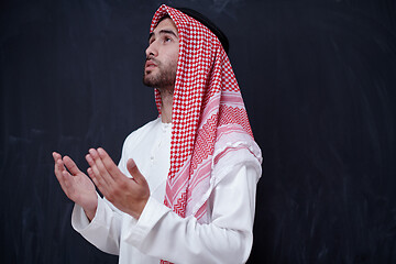 Image showing arabian man making traditional prayer to God, keeps hands in pra