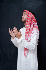 Image showing arabian man making traditional prayer to God, keeps hands in pra