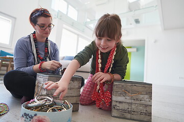 Image showing Mother and little girl daughter playing with jewelry  at home