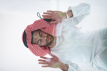 Image showing young arabian muslim man praying on the glass floor at home