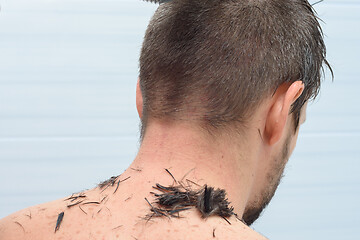 Image showing The back of the head of a man whose hair is cut at home in the bathroom