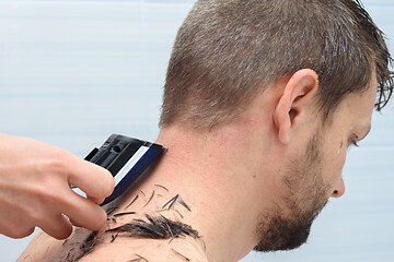 Image showing Hairdresser shaves hairs from the neck of a man