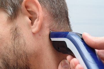 Image showing Hairdresser straightens hair on a man\'s neck