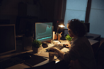 Image showing Man working in office alone during coronavirus or COVID-19 quarantine, staying to late night