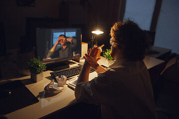 Image showing Man working in office alone during coronavirus or COVID-19 quarantine, staying to late night