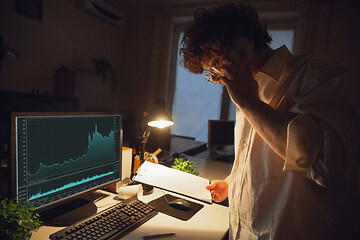 Image showing Man working in office alone during coronavirus or COVID-19 quarantine, staying to late night