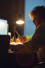 Image showing Man working in office alone during coronavirus or COVID-19 quarantine, staying to late night