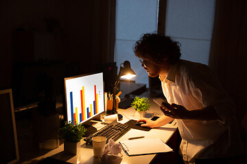 Image showing Man working in office alone during coronavirus or COVID-19 quarantine, staying to late night