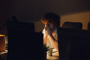 Image showing Man working in office alone during coronavirus or COVID-19 quarantine, staying to late night