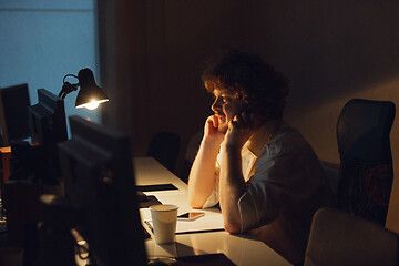 Image showing Man working in office alone during coronavirus or COVID-19 quarantine, staying to late night