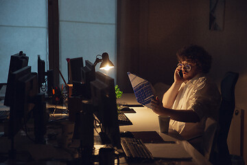 Image showing Man working in office alone during coronavirus or COVID-19 quarantine, staying to late night