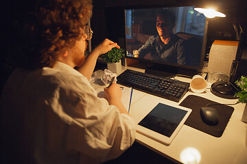 Image showing Man working in office alone during coronavirus or COVID-19 quarantine, staying to late night