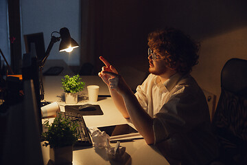 Image showing Man working in office alone during coronavirus or COVID-19 quarantine, staying to late night