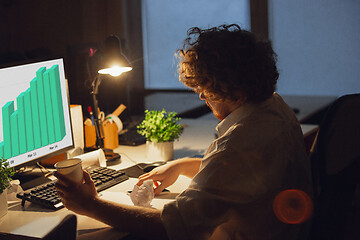 Image showing Man working in office alone during coronavirus or COVID-19 quarantine, staying to late night