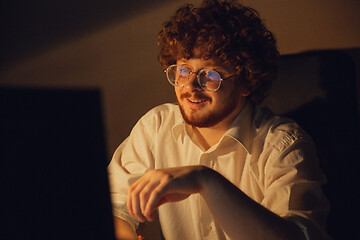 Image showing Man working in office alone during coronavirus or COVID-19 quarantine, staying to late night