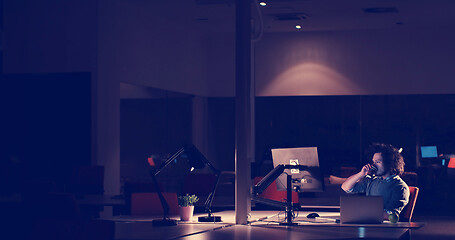 Image showing man working on computer in dark office