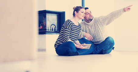 Image showing Young Couple using digital tablet on the floor