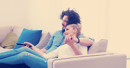 Image showing Young couple on the sofa watching television